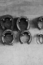 Load image into Gallery viewer, Limited Edition Western Art - Shoe Store 0217 Hand-Signed Artwork featuring a collection of horseshoes on a rustic wooden surface.