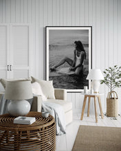 Load image into Gallery viewer, A cozy and bright room decorated with 'Riding Tide', a captivating photograph of a woman on a surfboard, creating a tranquil and beach-inspired atmosphere.