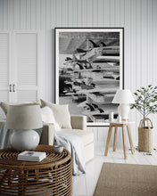 Load image into Gallery viewer, Beach Art: Surf School - A stylish living room featuring a large framed black-and-white photograph of surfboards on display, evoking coastal vibes and beach aesthetics.