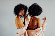 Load image into Gallery viewer, Art Photography of twins posed back-to-back, showcasing their beautiful natural curls and stylish outfits, emphasizing a mirror image effect in a serene studio setting.