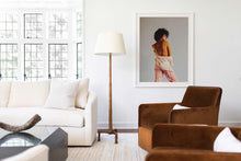 Load image into Gallery viewer, A cozy living room featuring the framed portrait photography titled "Tangerine" by Addison Jones Studio, with a model's back visible in the artwork.
