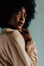 Load image into Gallery viewer, Close-up portrait of a model with curly hair, showcasing a 'Tightly Curled' wall art print in a serene setting, perfect for home decor.